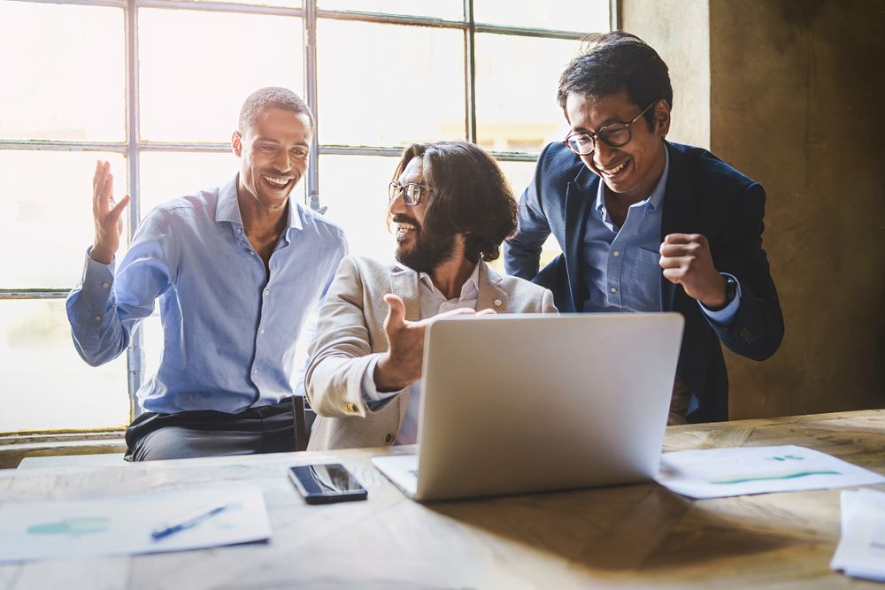 Three business professionals celebrating success together