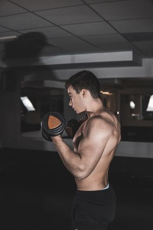 young fitness man doing weights