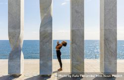 Side view of female doing yoga between sculpture by the sea bDjjNE