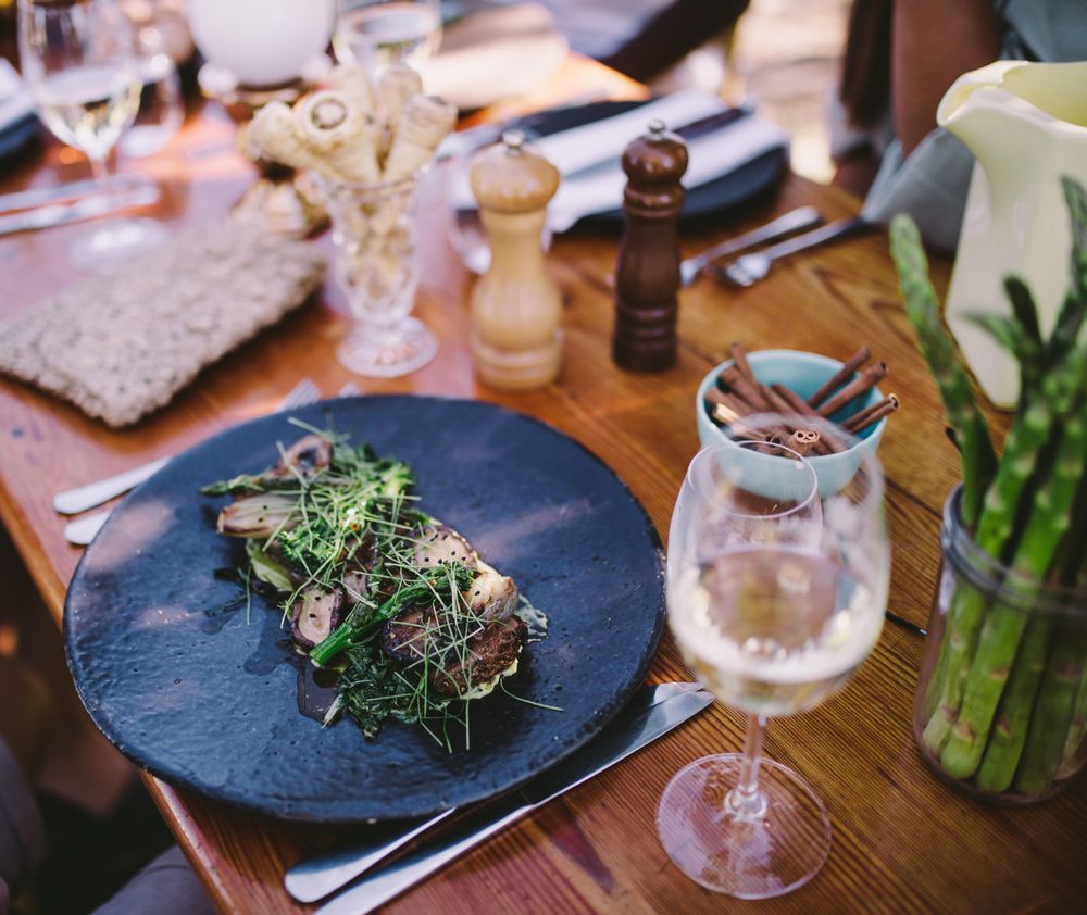 Elegantly plated steak with greens and wine