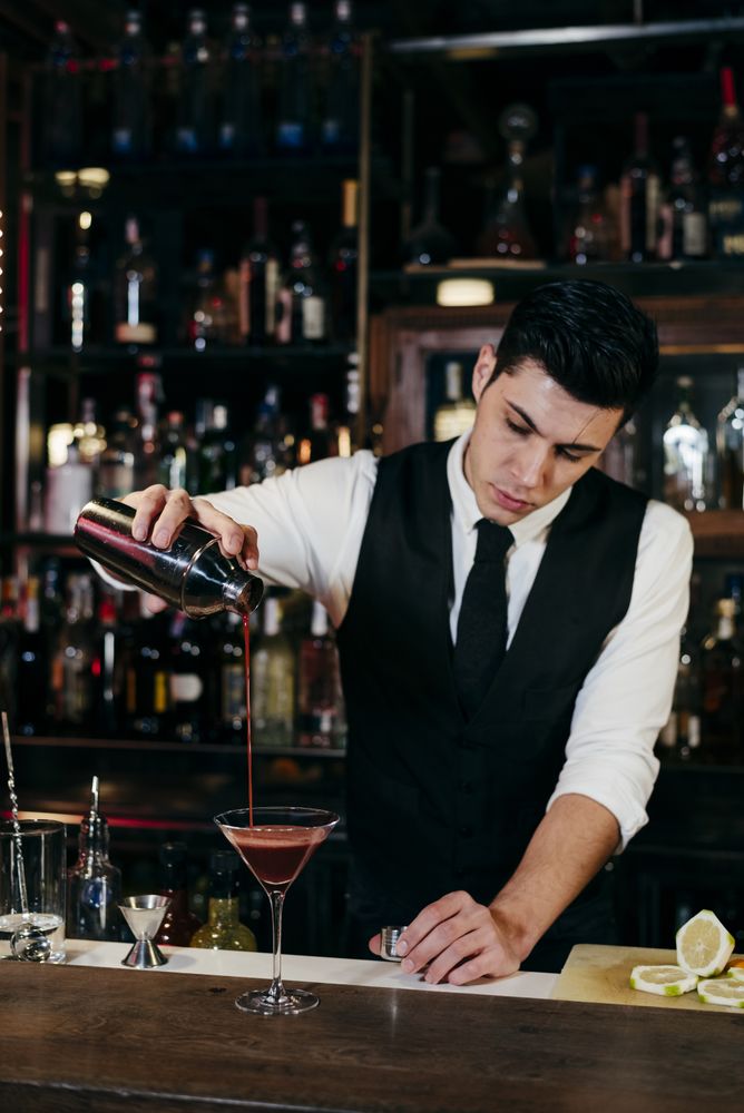 Barman working mixing pouring drink in a glass