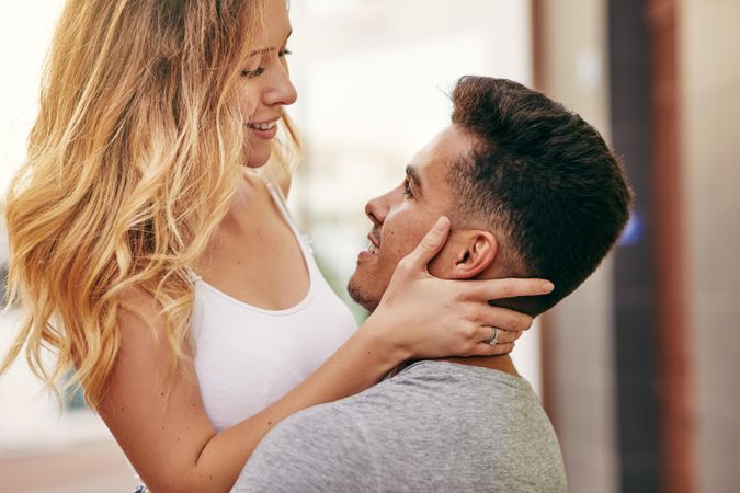 Man holding woman as they stare into each others eyes