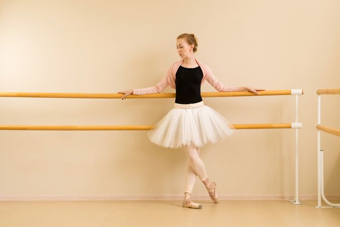 Ballet dancer standing in relaxed pose at barre