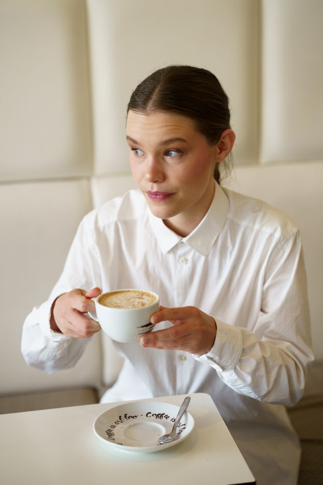 Woman in modern cafe sipping coffee