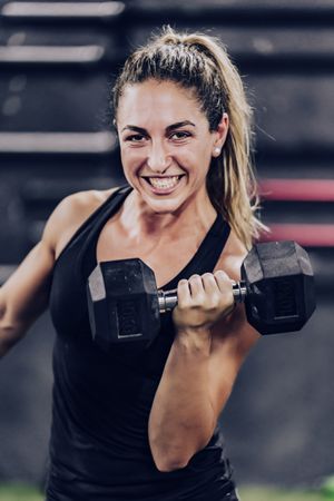 Muscular woman training with weight
