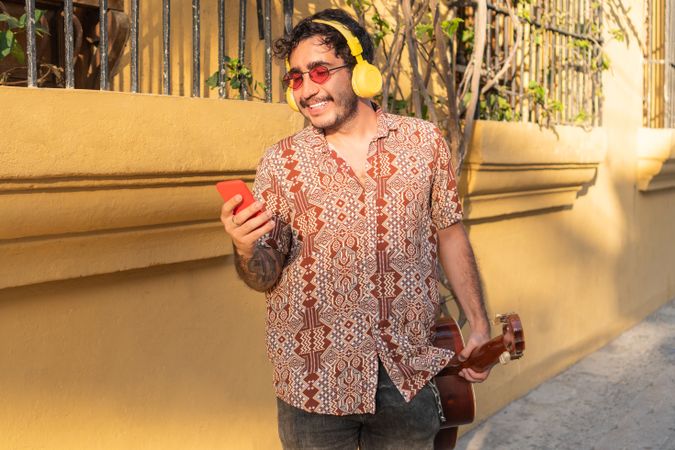 Portrait Of Young Latin Man Listening Music In The Street