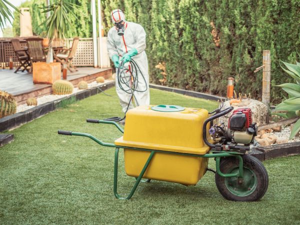Fumigator spinning grey hose in green yard