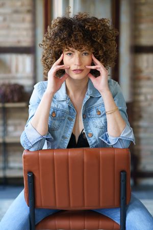 Woman sitting on backward chair
