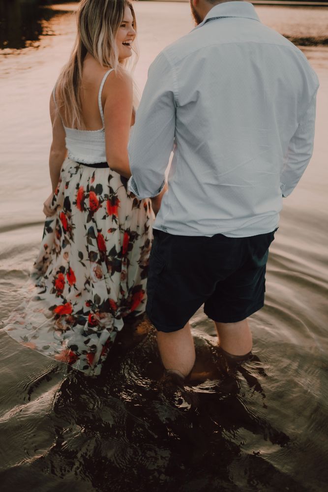 Loving couple hugging while standing ankle deep in water on beach