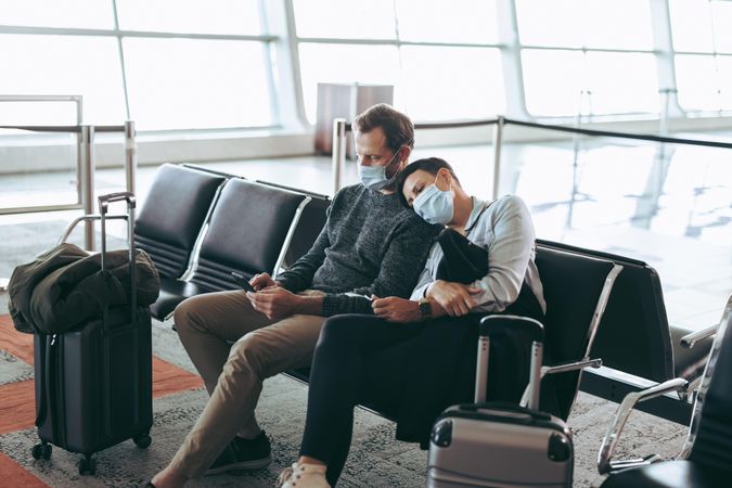 Traveler couple in pandemic waiting at airport terminal