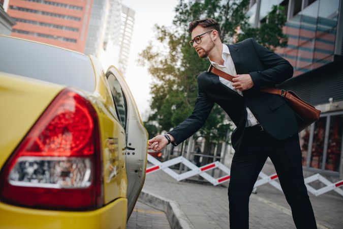 Man taking a taxi to go to office