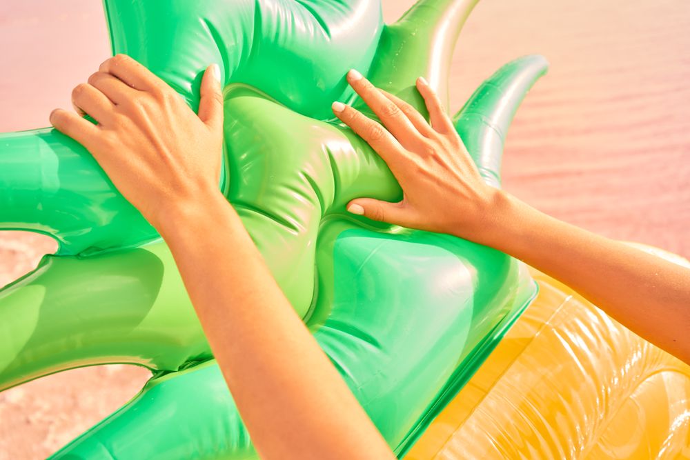 Female with air mattress on seashore in summer