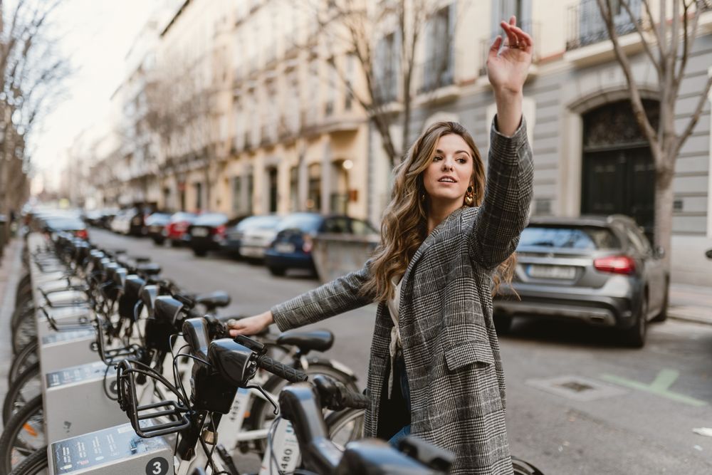 Woman choosing rental bicycle on parking lot