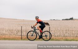 Woman riding on bicycle in in the autumn next to brown field bxkdd4