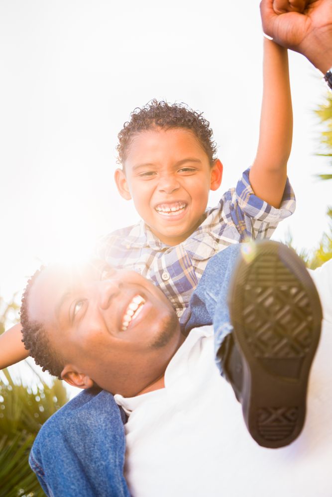 Son and Father Playing Piggyback Outdoors Together.