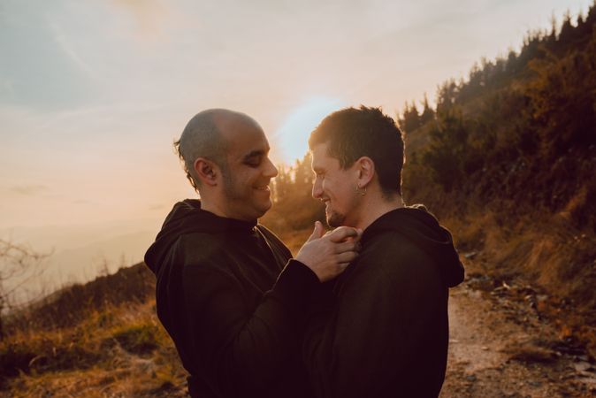 Men hugging and kissing in forest