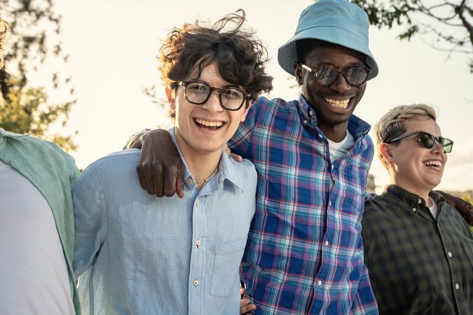 Energetic group of diverse young friends laughing and having fun outdoors.