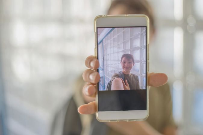 Screen of phone showing teenager taking selfie