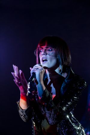 Stylish woman singing on stage