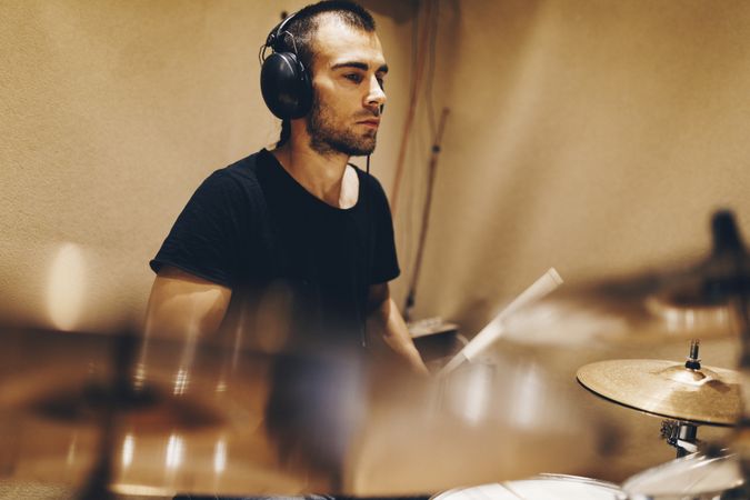Man with headphones playing on drums