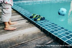 Feet of child on the side of the pool looking in 0g89W5