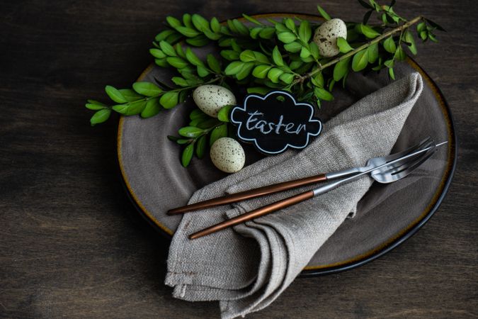 Spring table setting with small speckled eggs and foliage