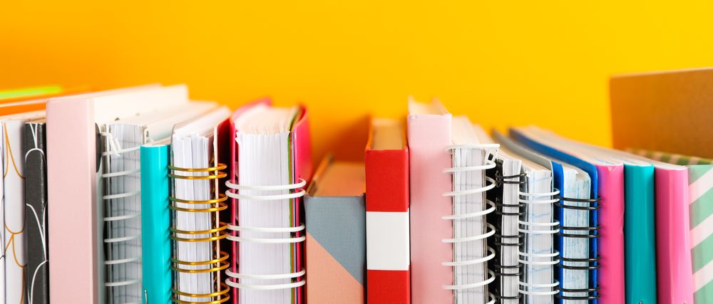 Stack of colorful books against background, space for text