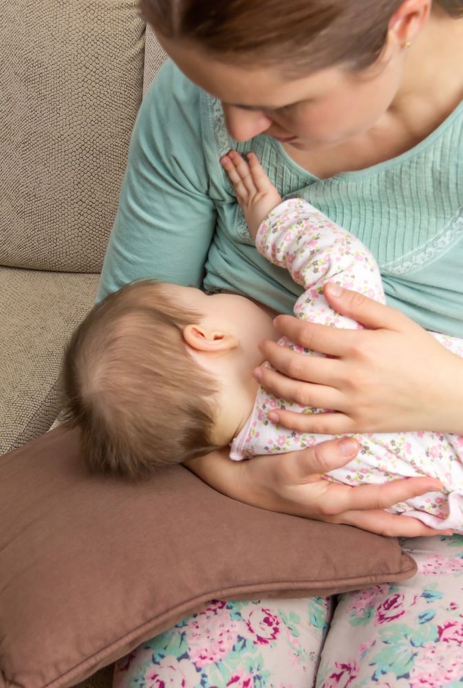 Baby breastfeeding with mother, vertical