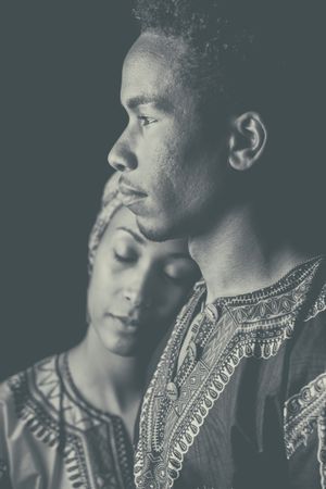 Woman with eyes closed clinging to ethnic man