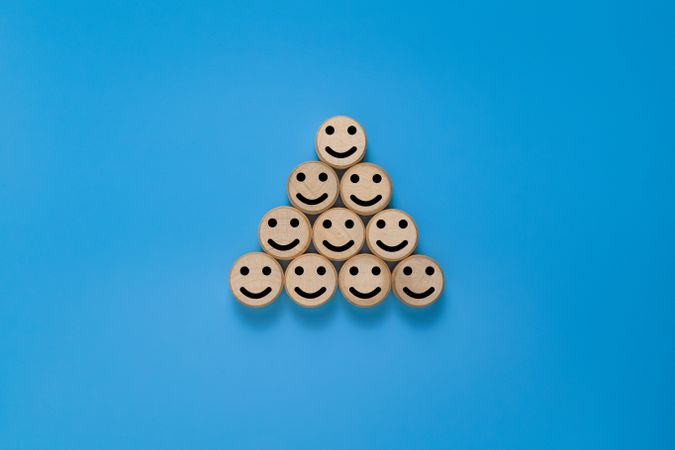 smile expression emoji on pyramid round wooden. isolated on blue background