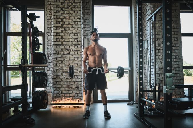 Black man exercising with barbell in gym