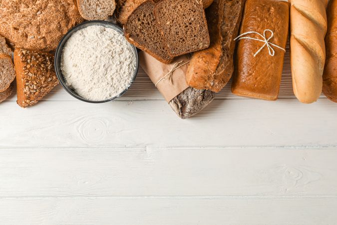 Flat lay composition with bakery products on wooden background, top view and space for text