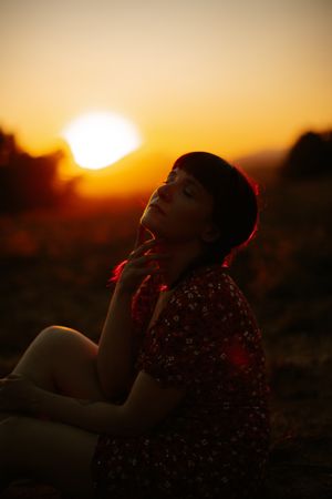 Woman touching sunset sky in nature