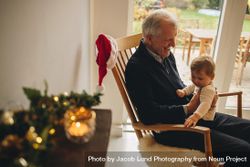 Older man sitting on chair and with his small grandson 0LAGy5