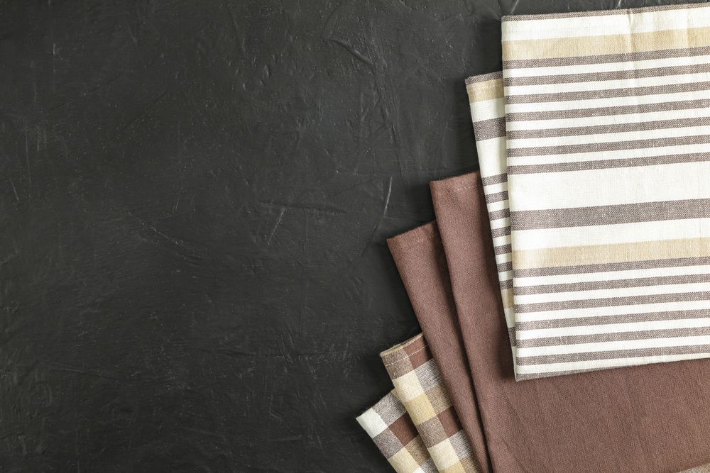 Fabric napkins on dark background, space for text