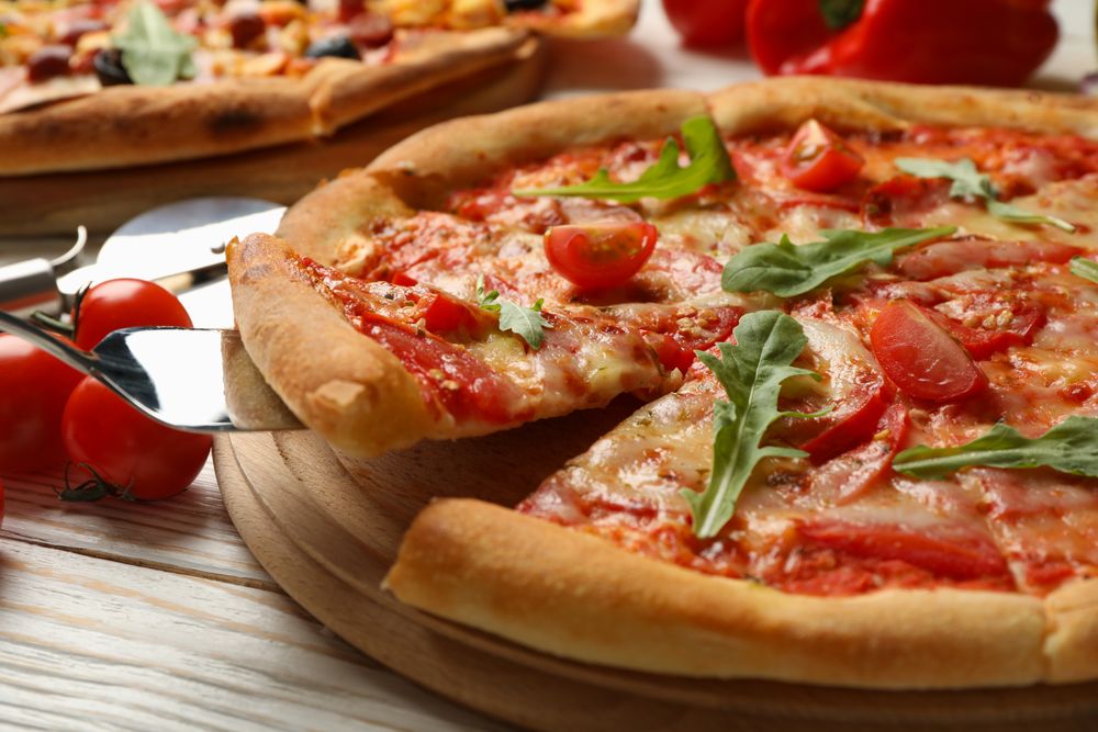 Tasty pizza and ingredients on wooden background