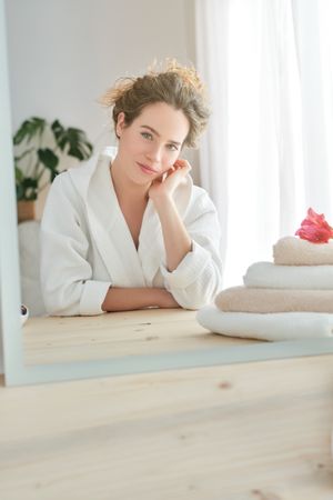 Content woman sitting near mirror