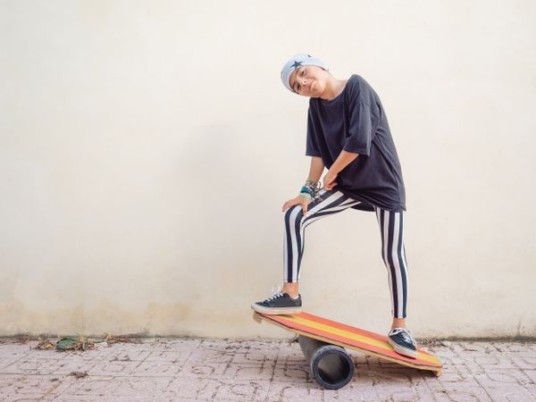 Cheeky boy standing on colorful board and swinging