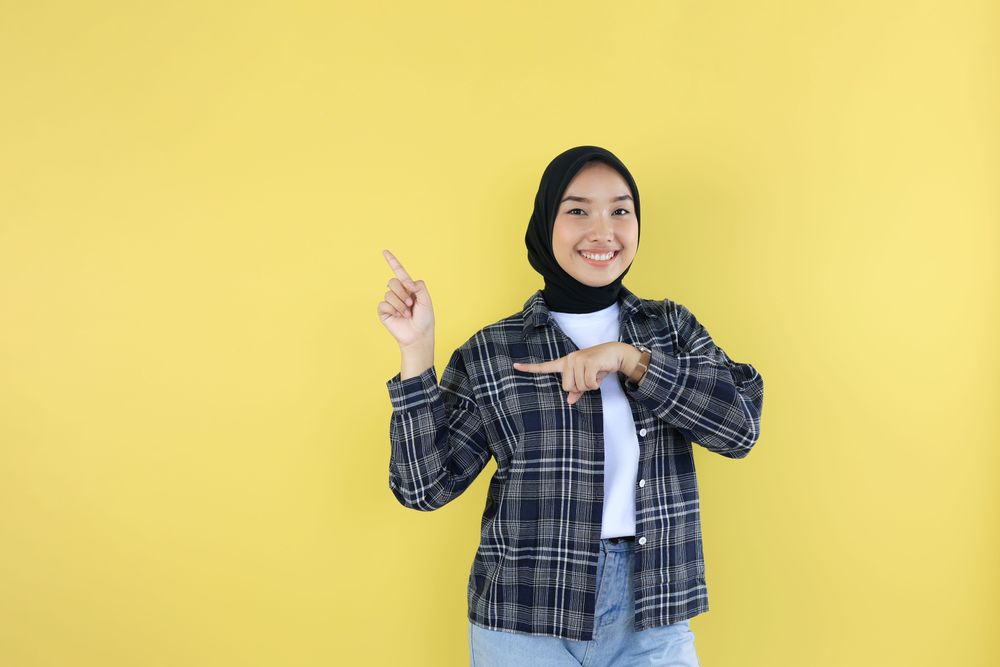 Happy Asian Muslim Woman Showing Copy Space on Finger