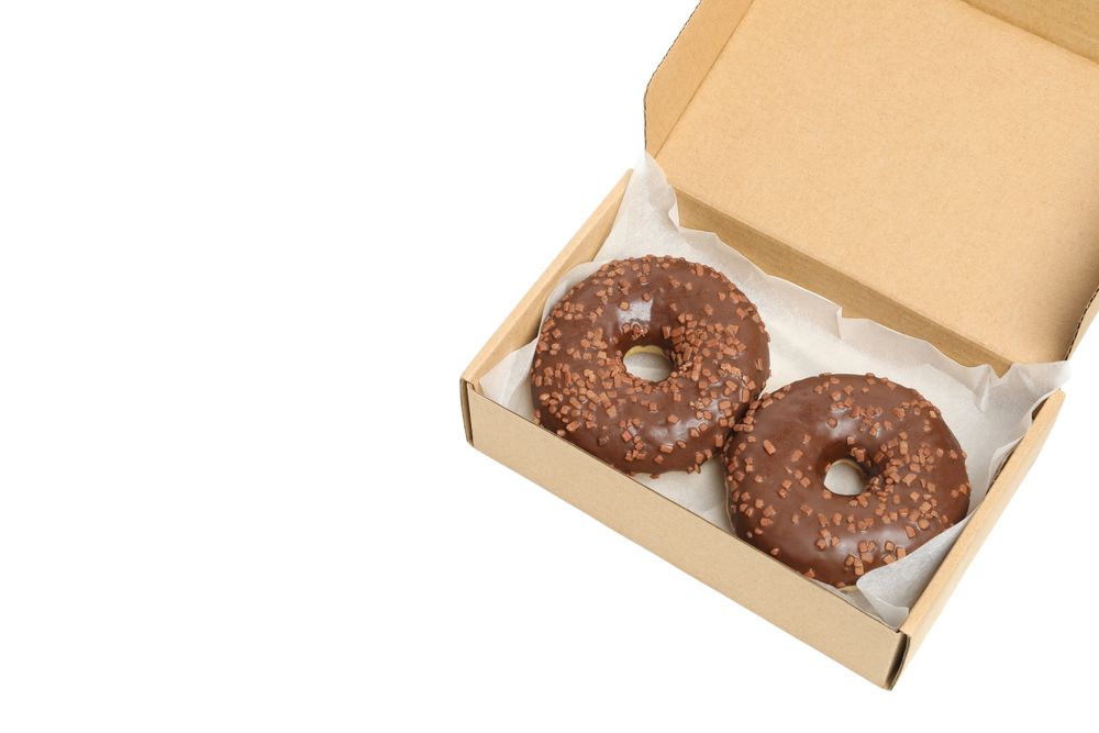 Carton box with donuts isolated on plain background
