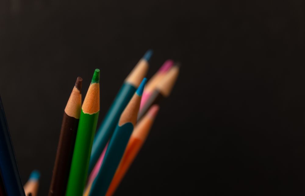 Multi colored pencils on dark background
