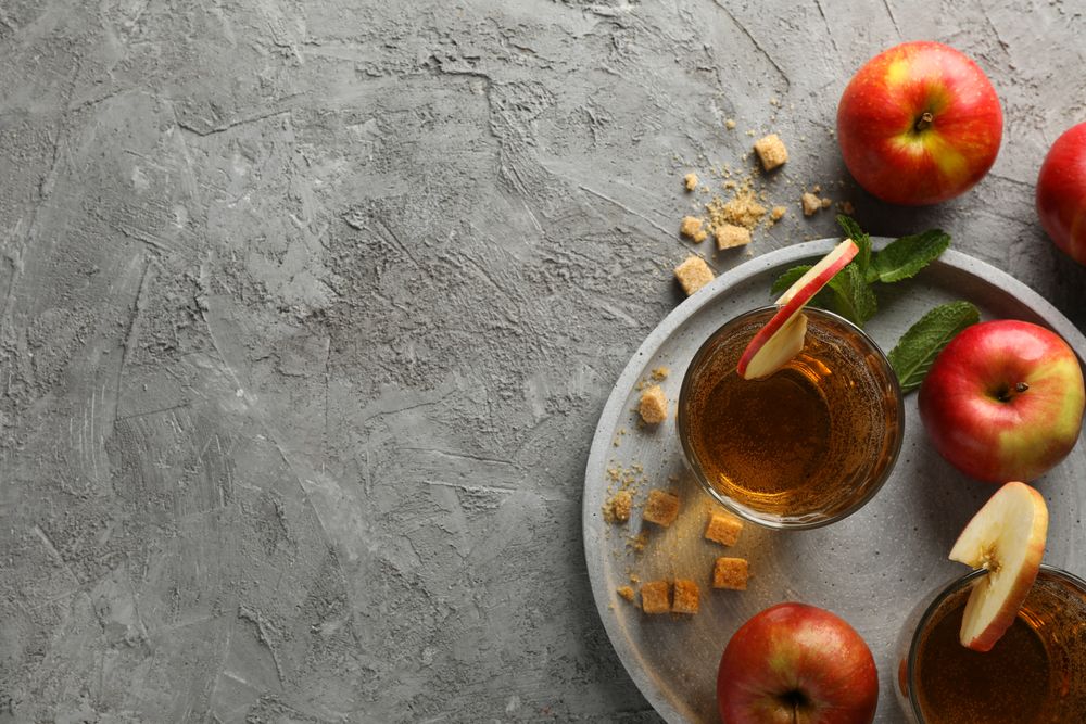 Composition with cider, sugar and apples on gray table
