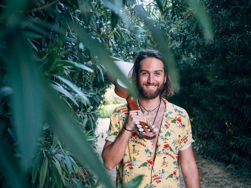 Hipster man in jungle with ukulele