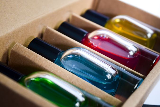 Close up of four different colored perfume bottles in a cardboard box