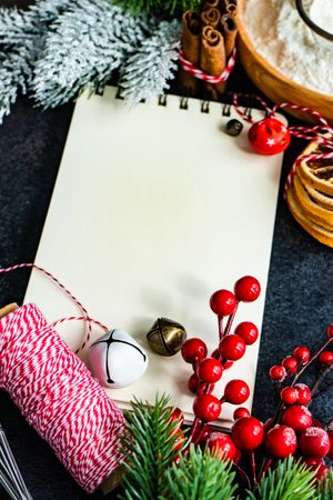 Blank notebook on table surrounded by Christmas decor and baking ingredients