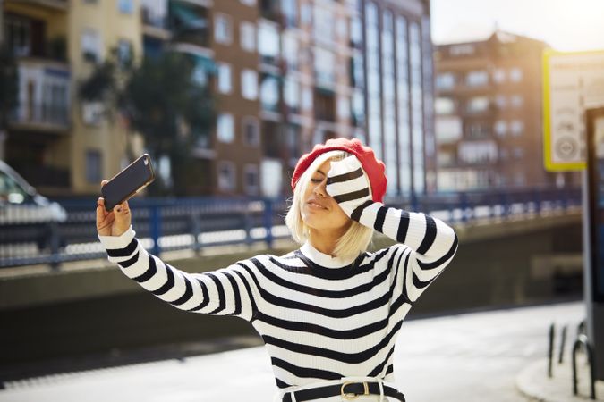 female in red beret taking selfie
