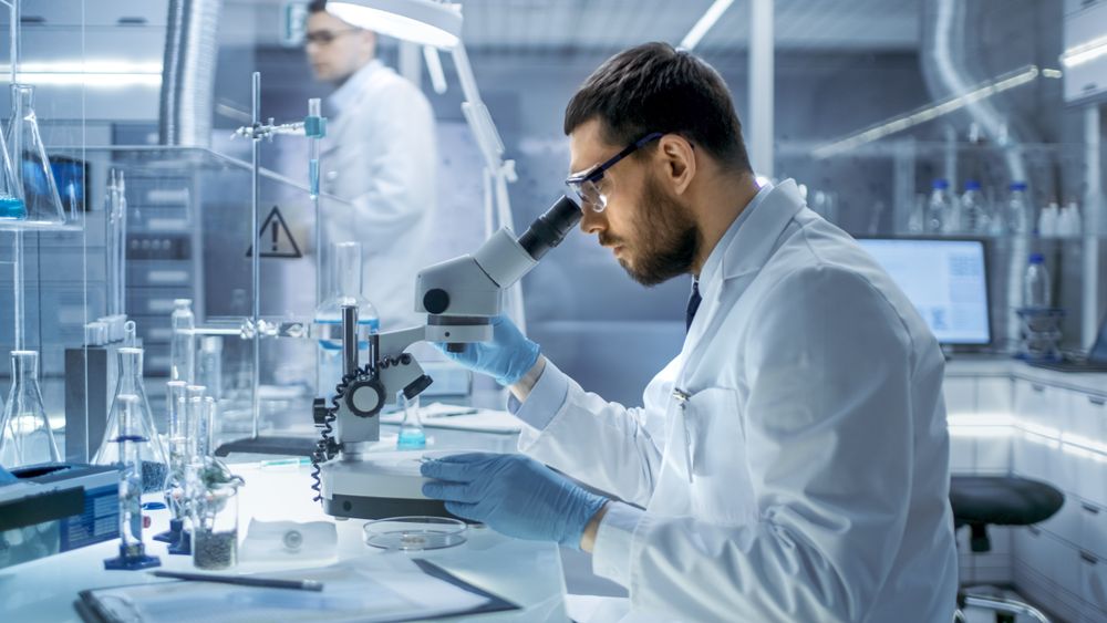 In a Modern Laboaratory Research Scientist Examines Substance Under Microscope.