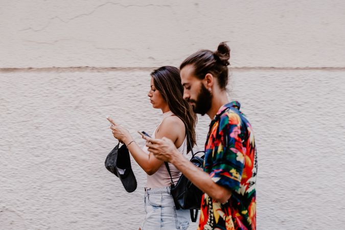 Modern couple walking and using smartphone