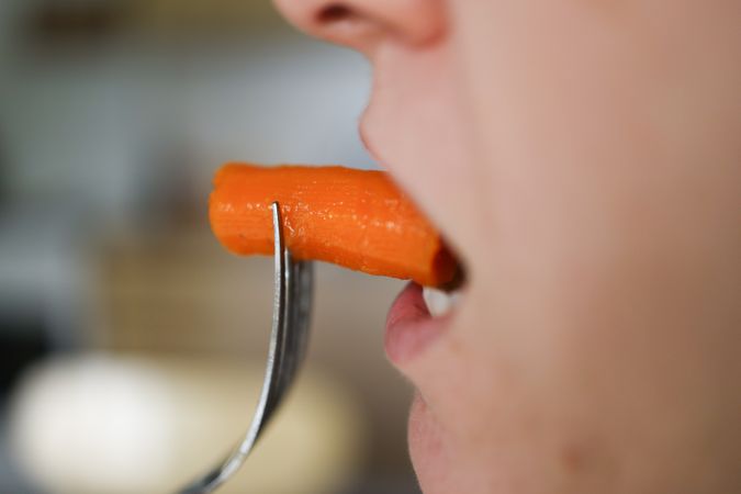 Woman Eating Carrot: Vitamin-Rich Nutritious Meal for Plant-Based Health.