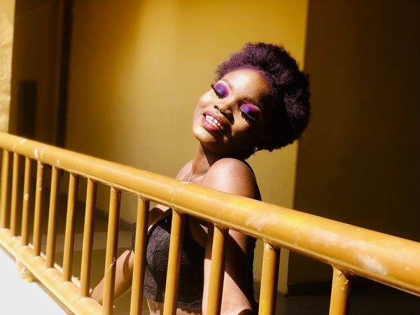 Woman with curly hair and eye make-up smiling